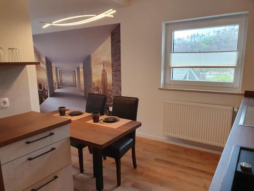 a dining room with a table and chairs and a window at Zwischen Frankfurt und Würzburg im schönen Odenwald in Obernburg am Main