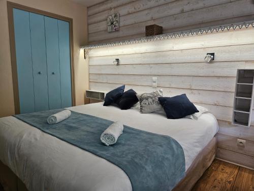 a bedroom with a large bed with a wooden wall at Hôtel Le Mont Barral in Creyers