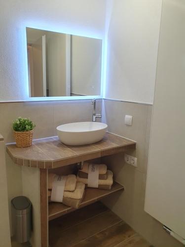 a bathroom with a sink and a mirror and towels at Zwischen Frankfurt und Würzburg im schönen Odenwald in Obernburg am Main