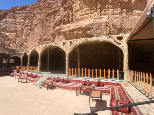 a group of benches in front of a mountain at Wadi Rum Santa Camp in Wadi Rum