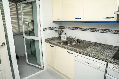 eine Küche mit weißen Schränken und einer Spüle in der Unterkunft Sea view apartment with great terrace and 4 pools - Duquesa Suites 430 in Manilva