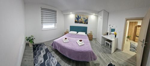 a bedroom with a purple bed and a sink at Apartman Pranić Mostar in Mostar