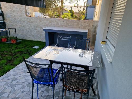 a table and two chairs on a patio at Apartman Pranić Mostar in Mostar