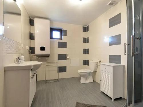 Un baño blanco con inodoro y lavabo. en Domki w stylu góralskim Myśliwska 20, en Grzybowo