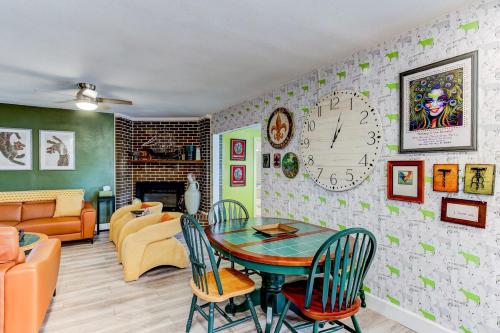 a living room with a table and a clock on the wall at Happy Palette Home Close to downtown Fenced yard in Sanford