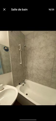 une salle de bain avec un lavabo, une baignoire et des toilettes dans l'établissement La grosse horloge, à La Rochelle