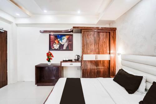 a bedroom with two beds and a wooden door at Super Hotel O SGPGI in Lucknow