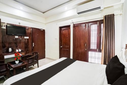 a bedroom with a bed and a desk and a television at Super Hotel O SGPGI in Lucknow