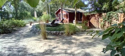 a person sitting on a bench in front of a cabin at Domek nad jeziorem Strykowskim in Sapowice