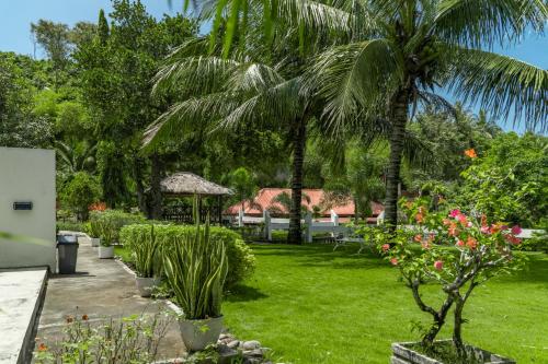 a garden with palm trees and a gazebo at The Hawk's Nest Resort in Sabong