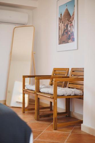 a room with two wooden chairs and a mirror at Don Ciccio Apartments&Suite in Conversano