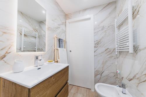 a white bathroom with a sink and a mirror at Don Ciccio Apartments&Suite in Conversano