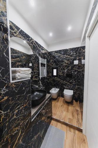 a black marble bathroom with two toilets and a sink at Don Ciccio Apartments&Suite in Conversano