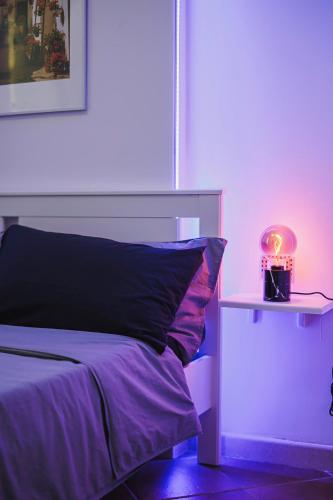 a bedroom with a bed with a pink light at Don Ciccio Apartments&Suite in Conversano