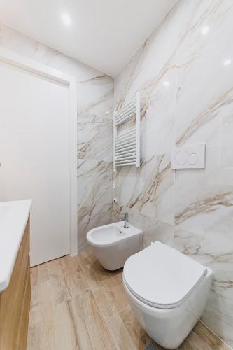 a white bathroom with a toilet and a sink at Don Ciccio Apartments&Suite in Conversano