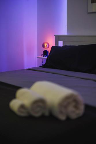 a purple room with a bed with a towel on it at Don Ciccio Apartments&Suite in Conversano