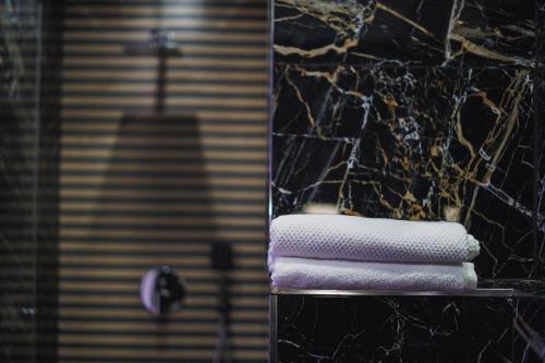a pile of towels sitting on a shelf in a bathroom at Don Ciccio Apartments&Suite in Conversano