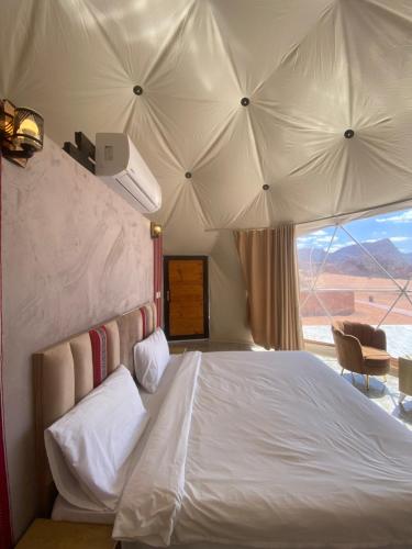 a bedroom with a bed with a view of the desert at Wadi Rum Santa Camp in Wadi Rum