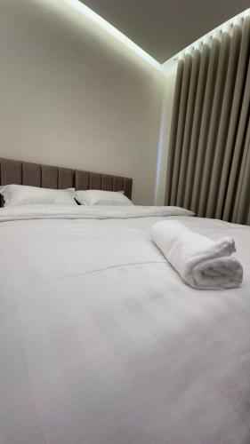 a white bed with white towels on top of it at يزن للاجنحة الفندقية in Aqaba