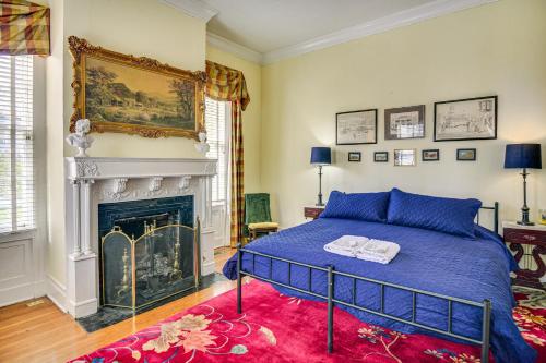 a bedroom with a blue bed and a fireplace at Historic Manor with Screened Porch in Elizabeth City in Elizabeth City
