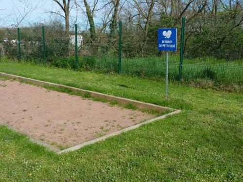 a sign in the grass next to a tennis court at Ibis Budget Roanne Hôtel in Roanne