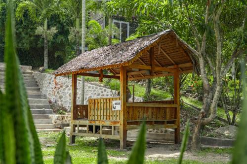 a wooden gazebo with a straw roof at The Hawk's Nest Resort in Sabong