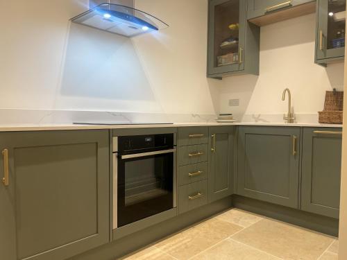 a kitchen with green cabinets and a sink at Central Oxford Studio 101 with Parking in Oxford