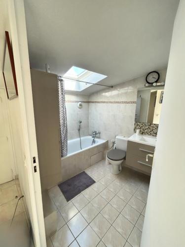 une salle de bain avec une baignoire, des toilettes et un lavabo dans l'établissement Étoile de la Baie des Anges, à Villeneuve-Loubet