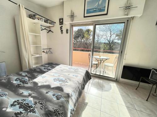 une chambre avec un lit et un balcon avec une table dans l'établissement Étoile de la Baie des Anges, à Villeneuve-Loubet