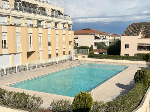 une grande piscine devant un immeuble dans l'établissement Étoile de la Baie des Anges, à Villeneuve-Loubet