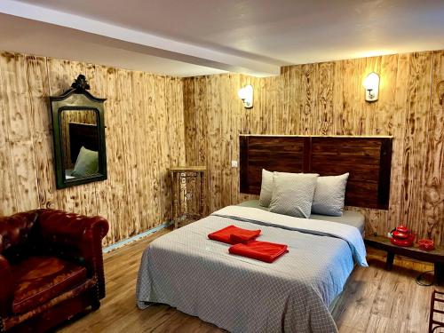 une chambre d'hôtel avec un lit et une chaise dans l'établissement La Porteille, à Ax-les-Thermes