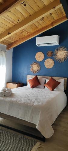 a bedroom with a large bed with a blue wall at Hotel Cabañas de los Angeles in Tequila