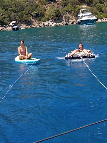 two women are sitting on rafts in the water at Yacht-Urlaub in den Buchten von Datca in Datca