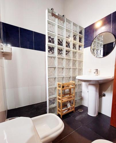 a bathroom with a sink and a toilet and a mirror at Casa do Beco in Angra do Heroísmo
