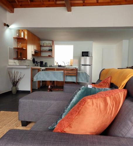 a living room with a couch and a kitchen at Casa do Beco in Angra do Heroísmo