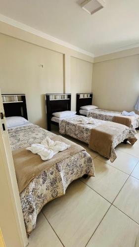 a group of three beds in a room at Apto Lindo e Amplo, 150m Praia in Cabedelo