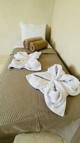 a bed with towels and pillows on it at Apto Lindo e Amplo, 150m Praia in Cabedelo