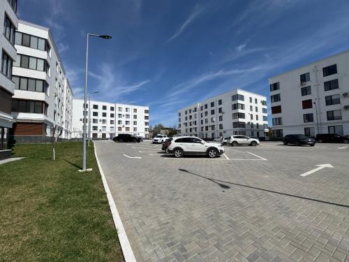 a parking lot with cars parked in front of buildings at Inamstro Home in Orhei