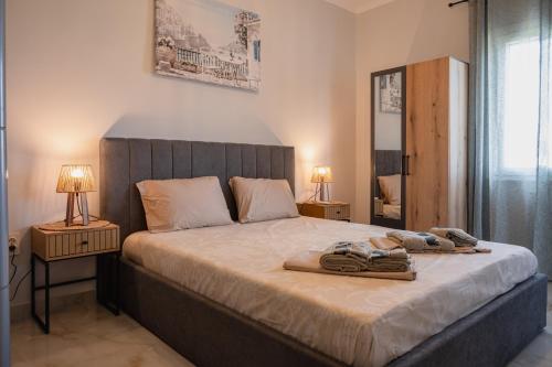a bedroom with a bed with two lamps and a mirror at Nero Blu by the Sea in Nea Kalikratia