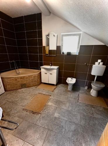 a bathroom with a tub and a toilet and a sink at Kuća za odmor Aiman in Mahala