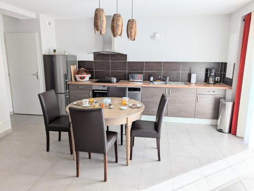a kitchen with a table and chairs in a room at Le Refuge Terre Horizon in Treffléan