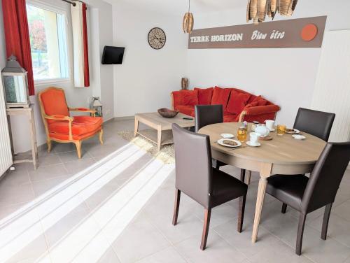 un salon avec une table et des chaises en bois dans l'établissement Le Refuge Terre Horizon, à Treffléan