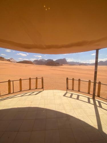 a view of the desert from a building with a bench at Wadi Rum Santa Camp in Wadi Rum