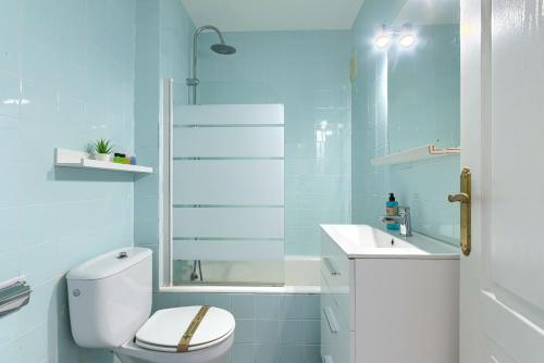 a blue bathroom with a toilet and a sink at Coast & Beach View Parking in Bakio