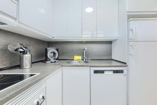 a white kitchen with white cabinets and a sink at Coast & Beach View Parking in Bakio