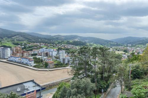 a view of a city with mountains in the background at Coast & Beach View Parking in Bakio