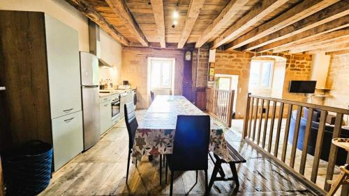 a kitchen with a table with chairs and a counter at Gîte de France Des alpagas 2 épis - Gîte de France 12 personnes MAE-9944 in Chaumeil