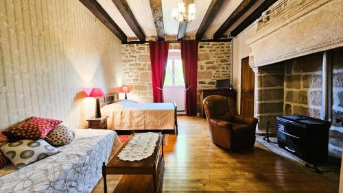 a bedroom with a bed and a couch and a fireplace at Gîte de France Des alpagas 2 épis - Gîte de France 12 personnes MAE-9944 in Chaumeil