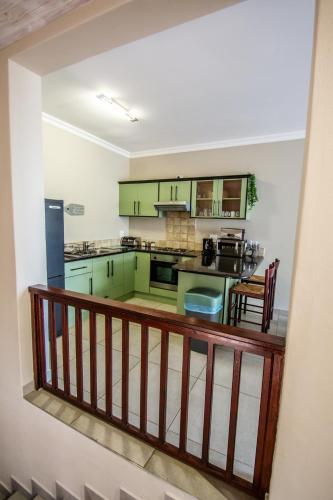 a kitchen with green cabinets and a balcony at Long Beach Selfcatering Namibia in Langstrand