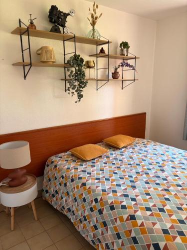 - une chambre avec un lit et des étagères sur le mur dans l'établissement cottage cosy du golf avec piscine, à Ploemel